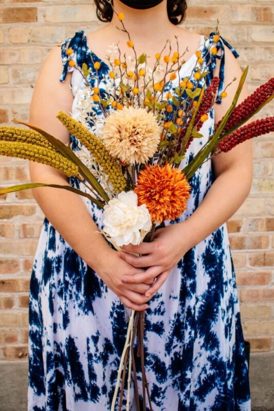 person holding a faux floral bouquet