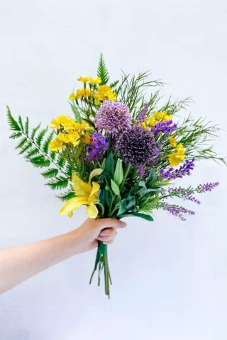 person holding a faux floral bouquet