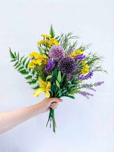 person holding a faux floral bouquet